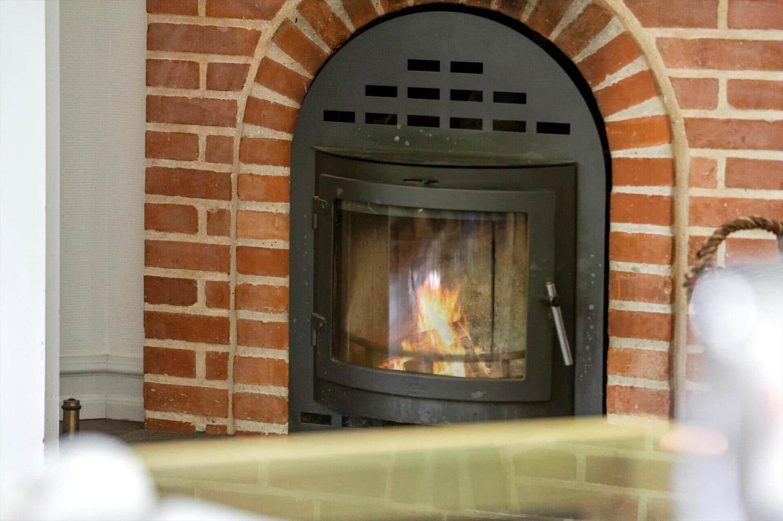 Ein Kaminofen mit brennendem Feuer in einem roten Ziegelofen.