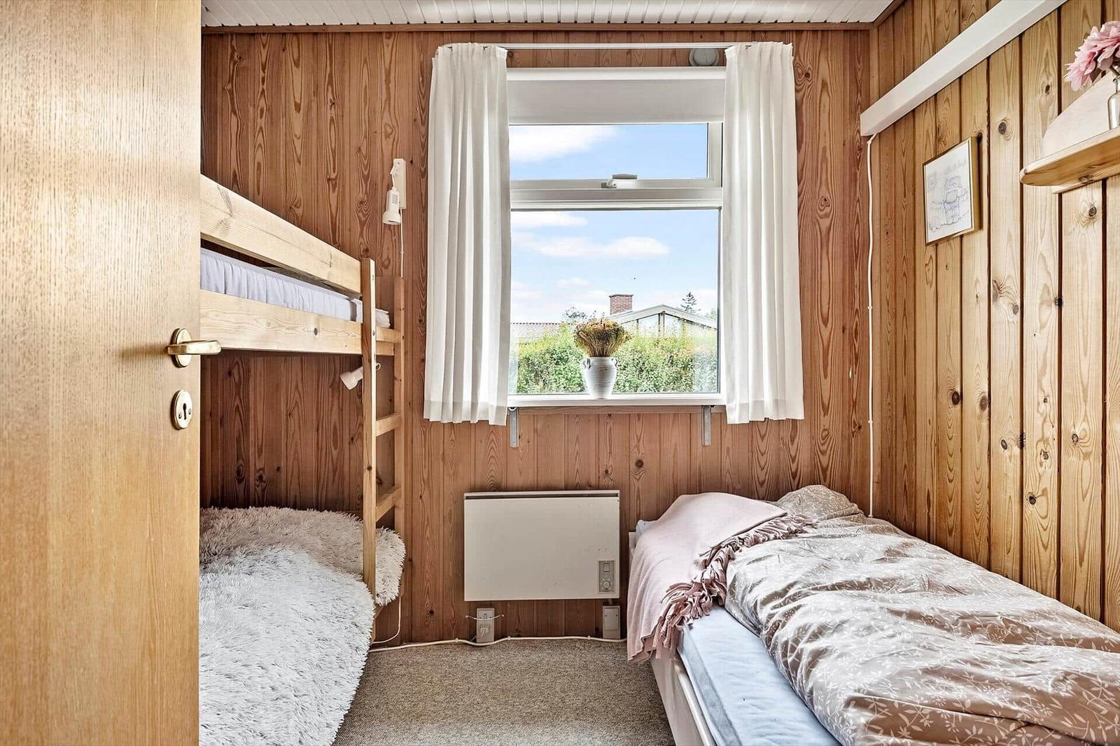 Zimmer mit Doppelbett, Etagenbett und Fenster mit Blick.