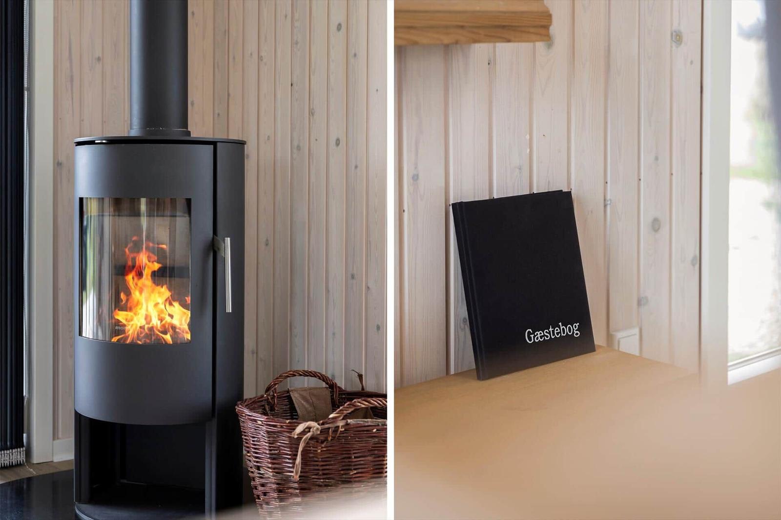 Holzwand, Kaminofen mit Flamme und Korb. Gäsgebog auf Holztisch.