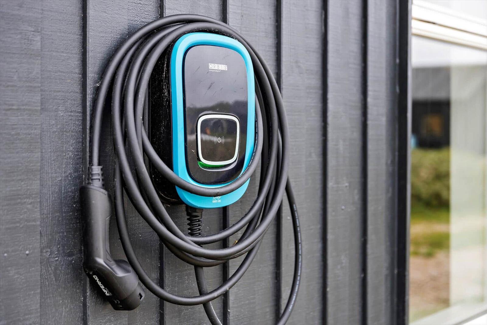 Ladestation mit Kabel an Hauswand montiert.