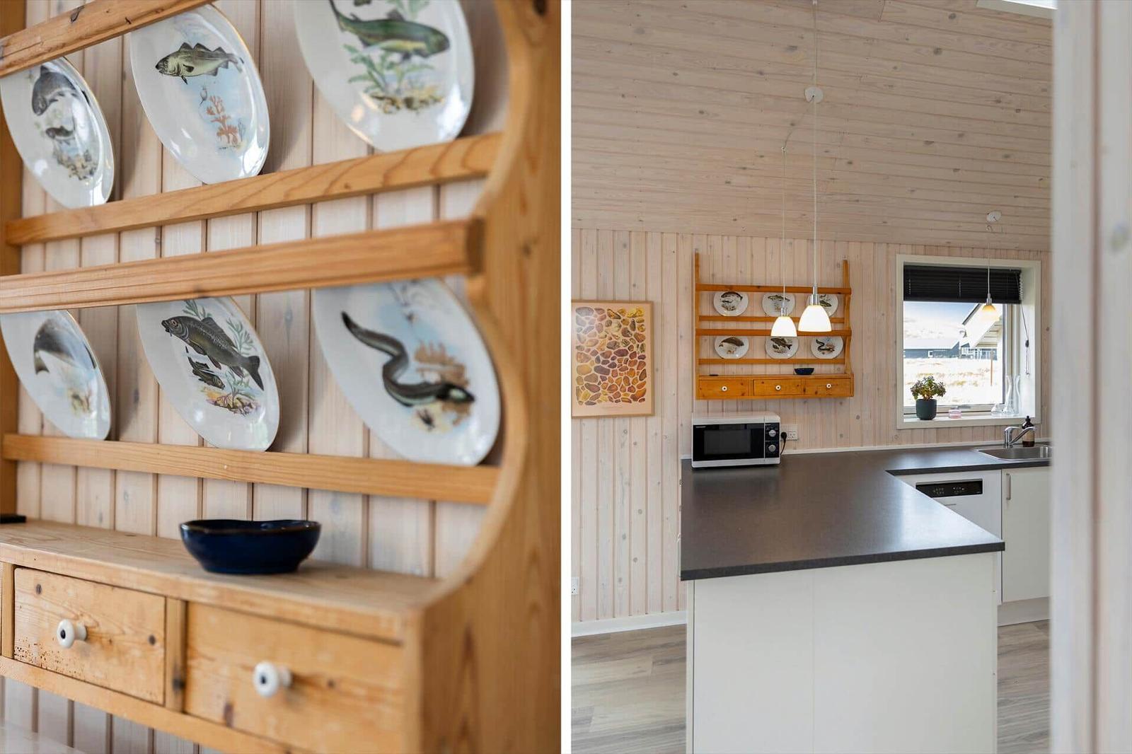 Küche mit Holzwand und Kücheninsel. Wandregal mit dekorativen Tellern.
