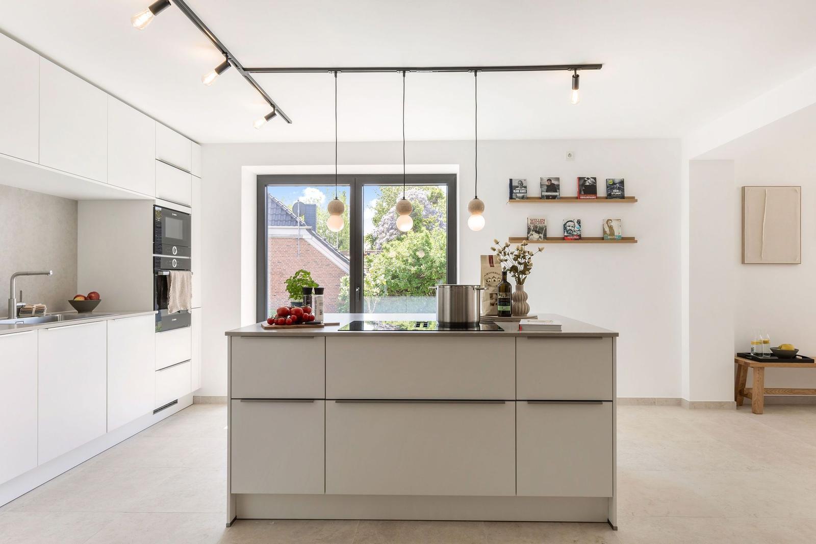 Moderne Küche mit Kücheninsel, Fenster und Regalen.