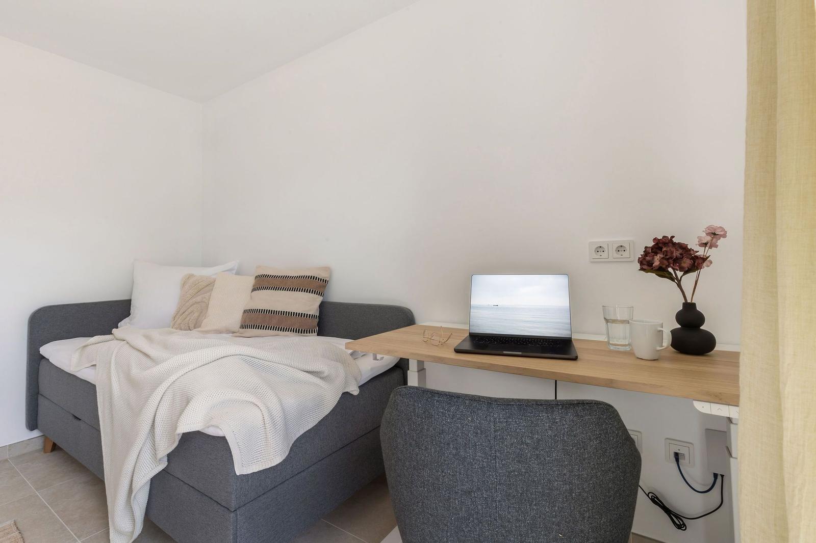 Schlafzimmer 1 im EG mit Einzelbett & Home Office Platz (höhenverstellbarer Schreibtisch)