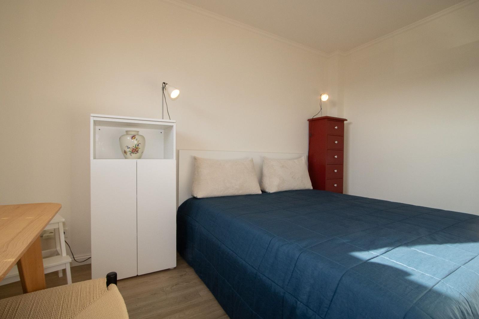 Schlafzimmer mit Bett, Schrank und Tisch