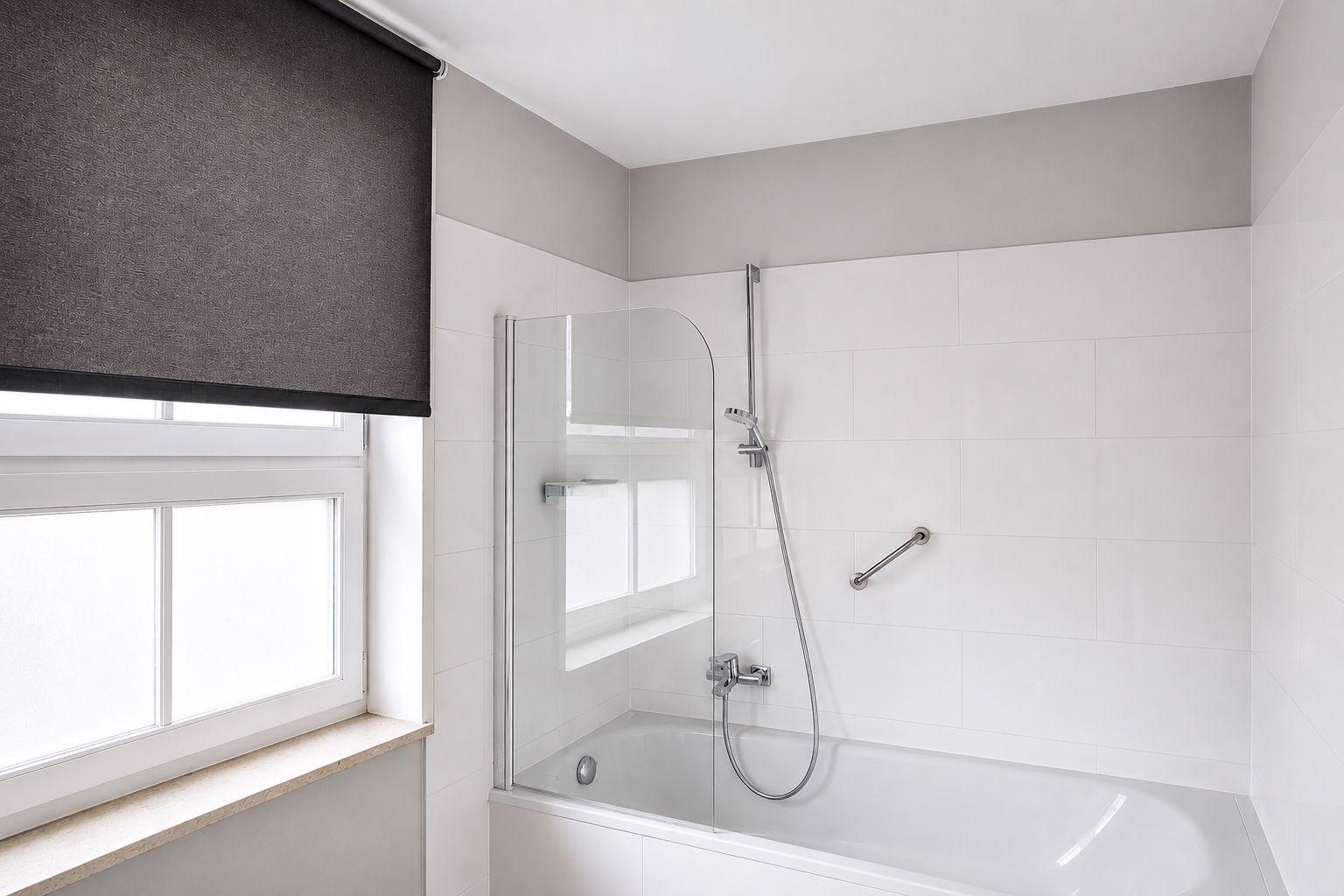 Badezimmer mit Dusche und Fenster mit Rollladen.