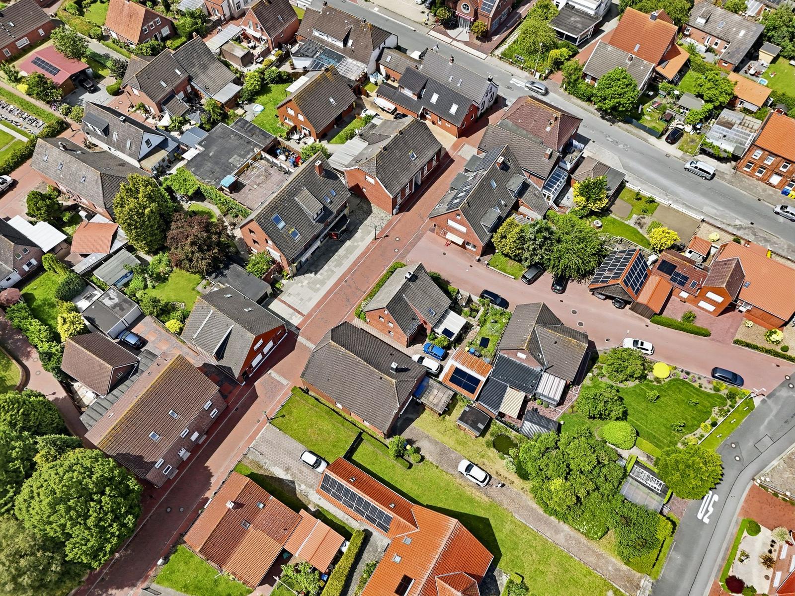 Luftbild eines Wohngebiets mit Häusern, Grünflächen und Straßen.