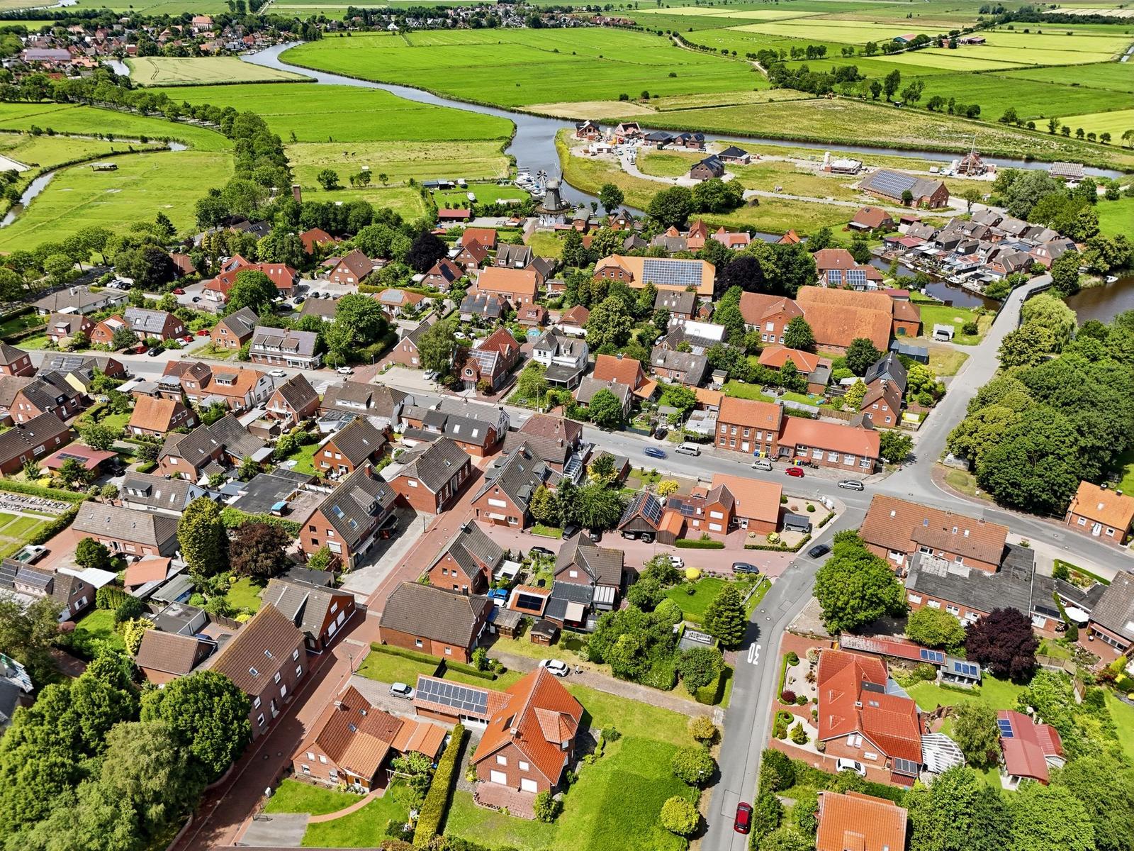 Aussicht auf ländliche Siedlung mit Häusern, Grünflächen und Fluss.