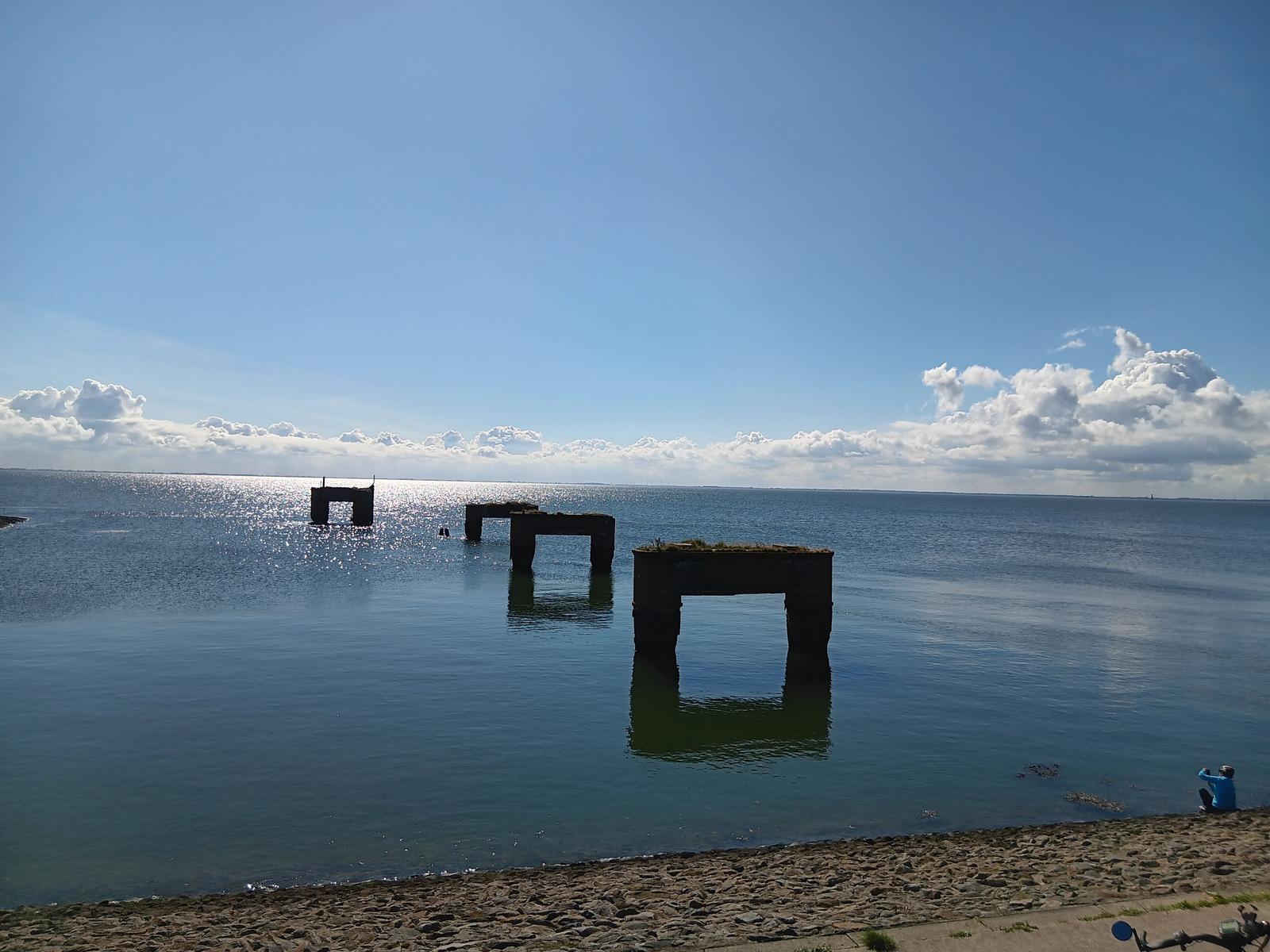 Meer mit Ruinen im Hintergrund, Strand im Vordergrund