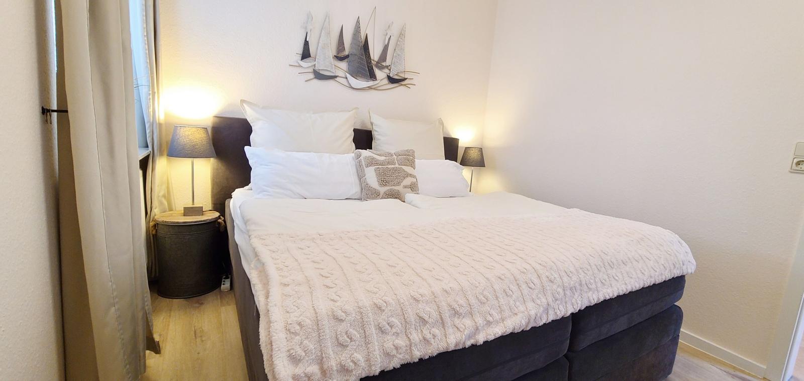 Schlafzimmer mit Bett, Nachttisch und Wanddekoration