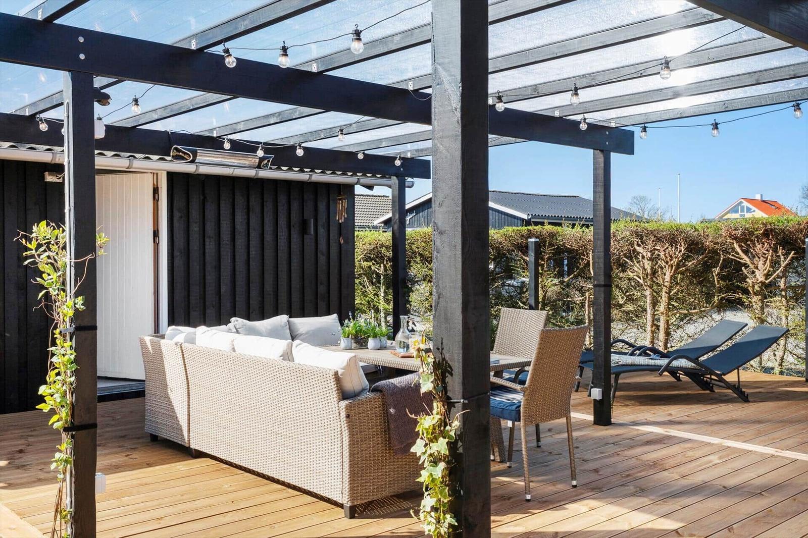 Terrasse mit Sitzgelegenheiten unter einer Markise mit Lichterkette.