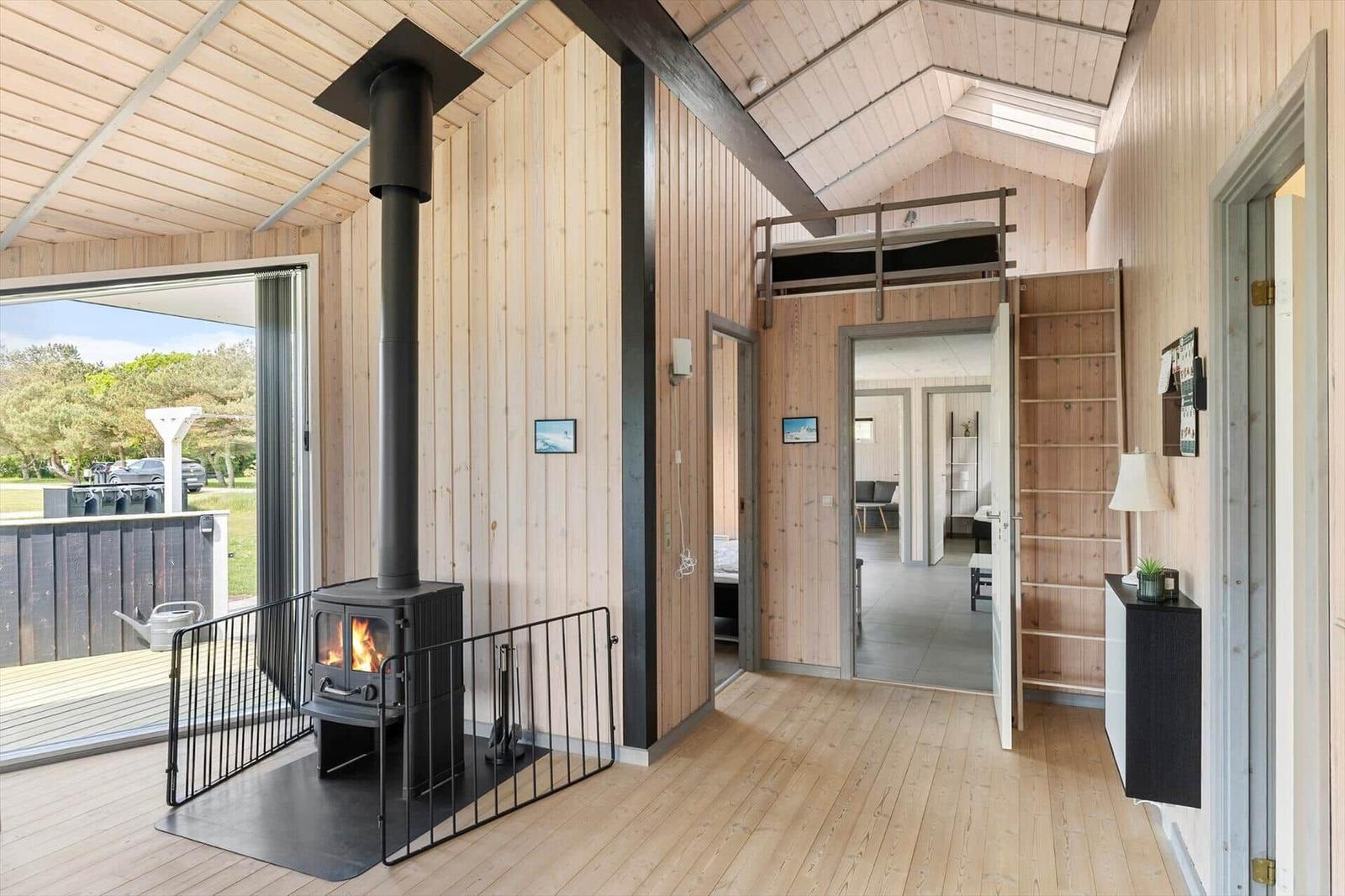 Holzhaus mit Kamin, Schlafgelegenheit oben und Blick auf den Garten.