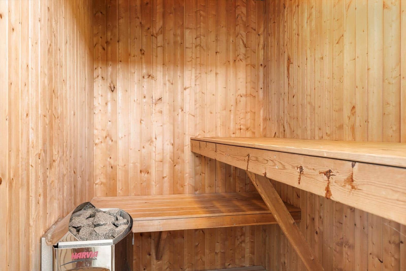 Sauna mit Holzwandverkleidung und mehreren Sitzbänken.