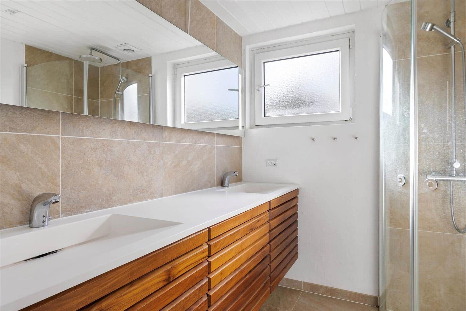 Badezimmer mit Dusche, Waschbecken und Spiegel