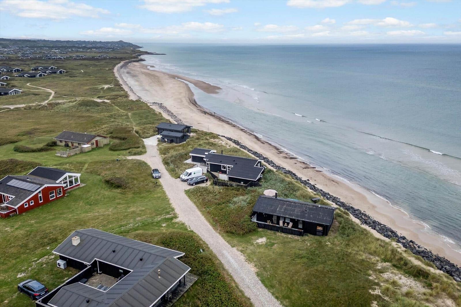 Aerielansicht von Strandhäusern mit Grünflächen und Meeresblick.
