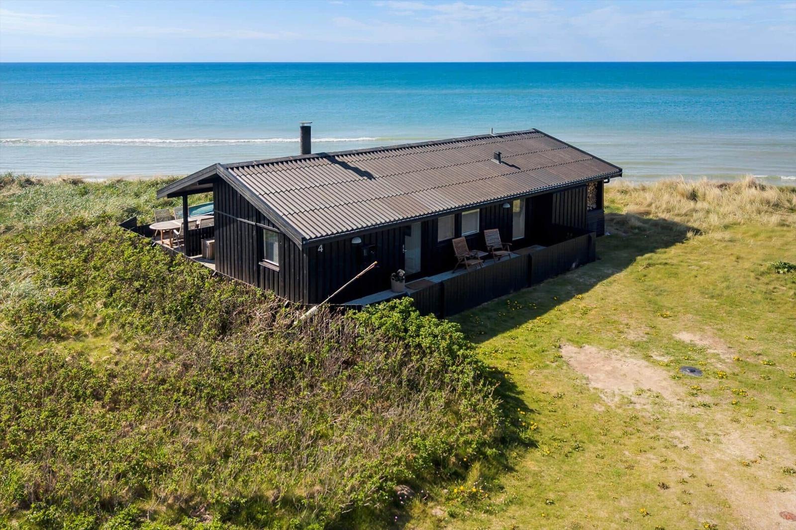 Schwarzes Strandhaus mit Terrasse und Meerblick