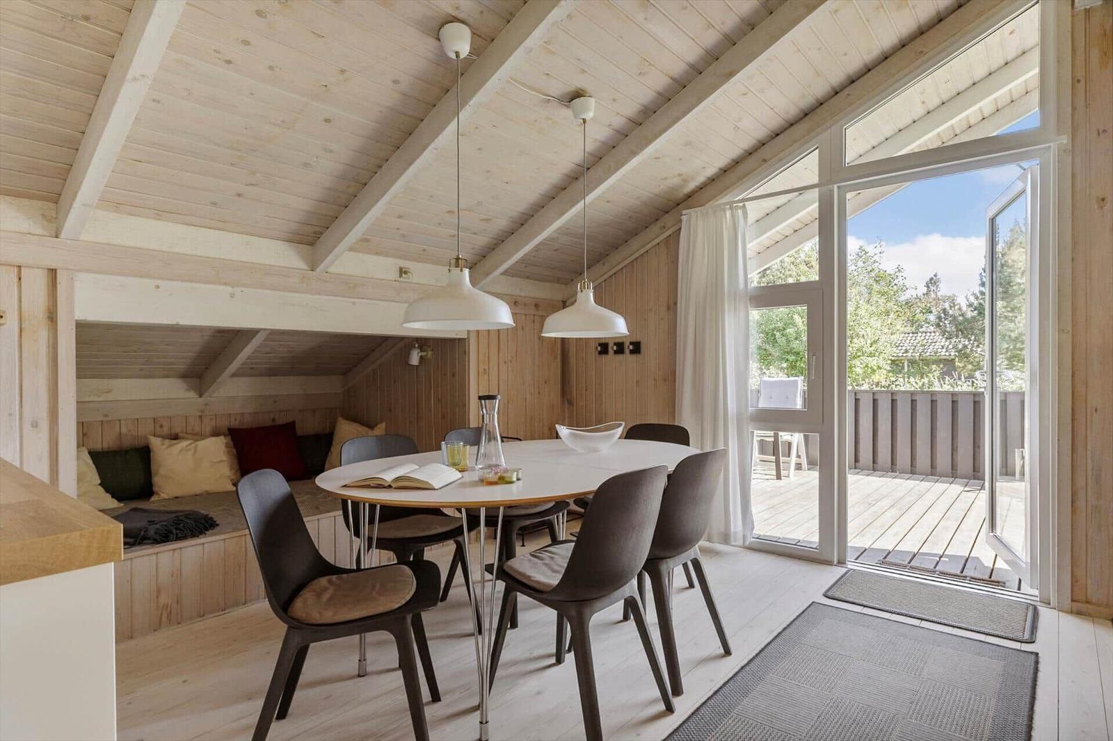 Essbereich mit runden Tisch, Stühlen und Blick auf Balkon.