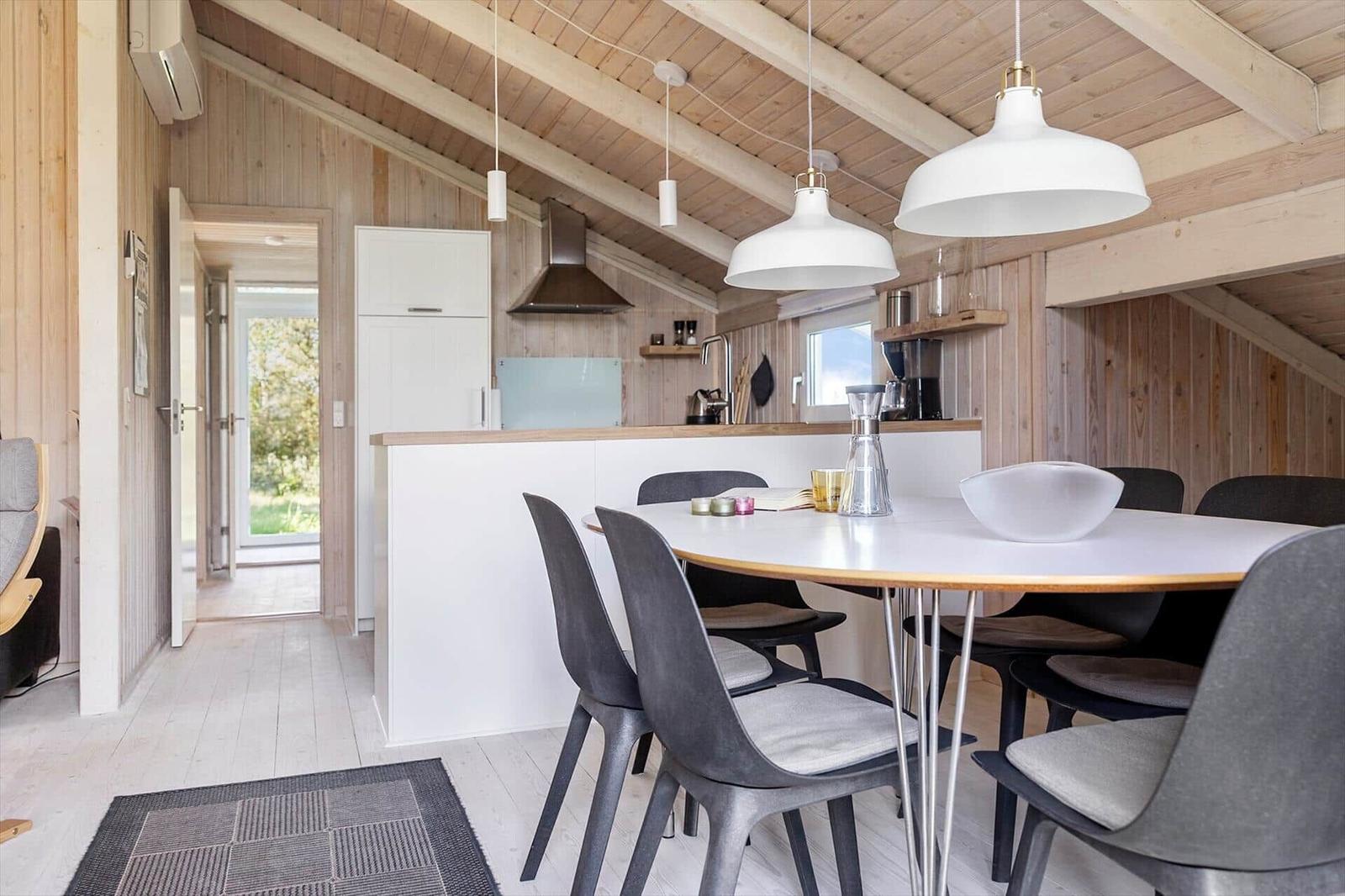 Essbereich mit Tisch und Stühlen, Küchenzeile und Holzdecke