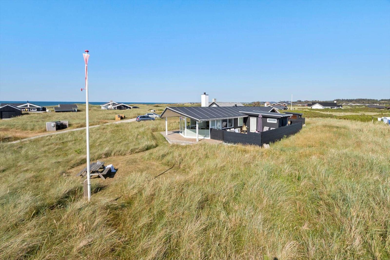 Moderne Strandvilla mit Terrasse und Garten. Blick auf das Meer und Dünen.