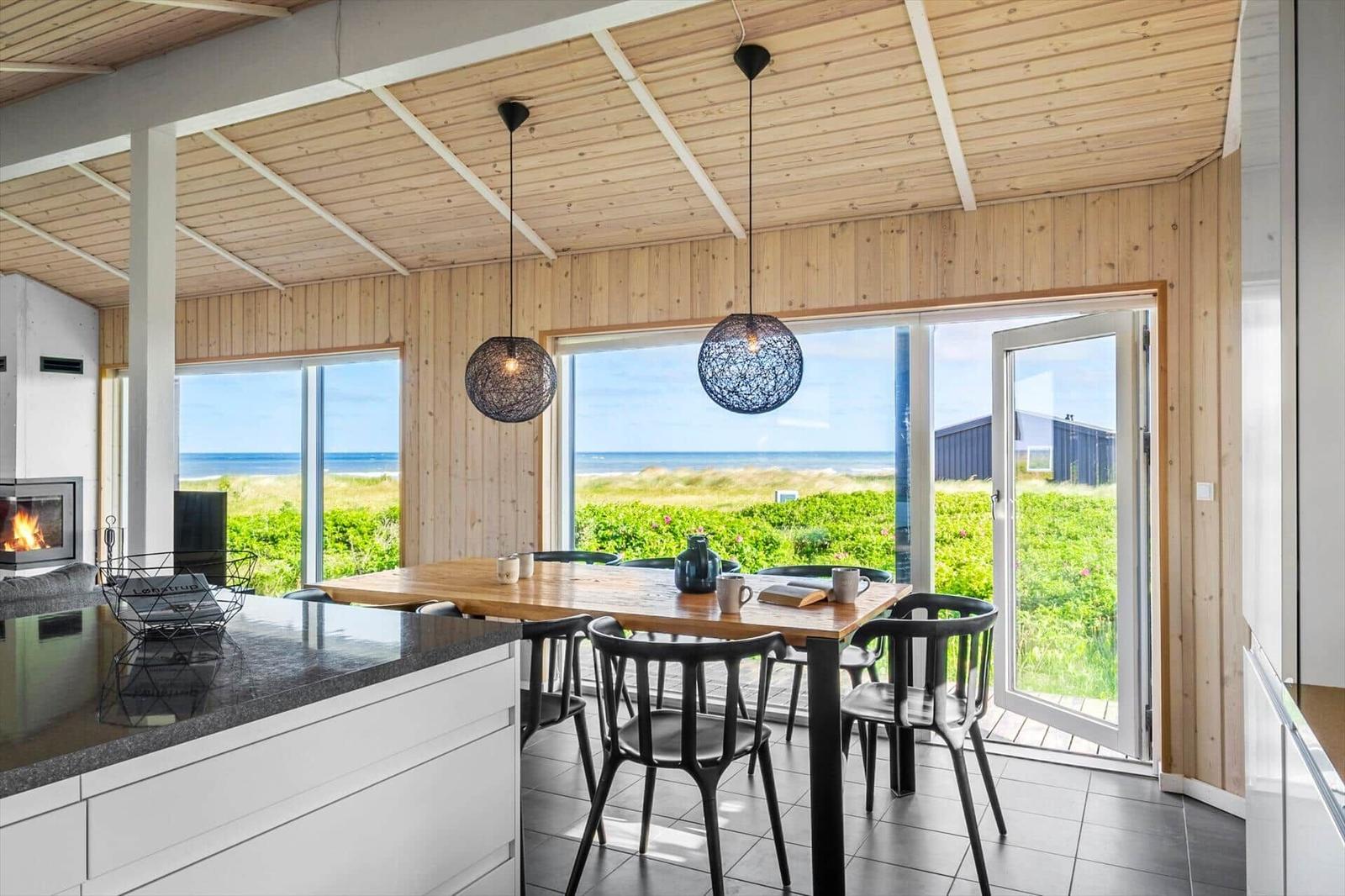 Essbereich mit Blick auf die Nordsee und grüne Landschaft.