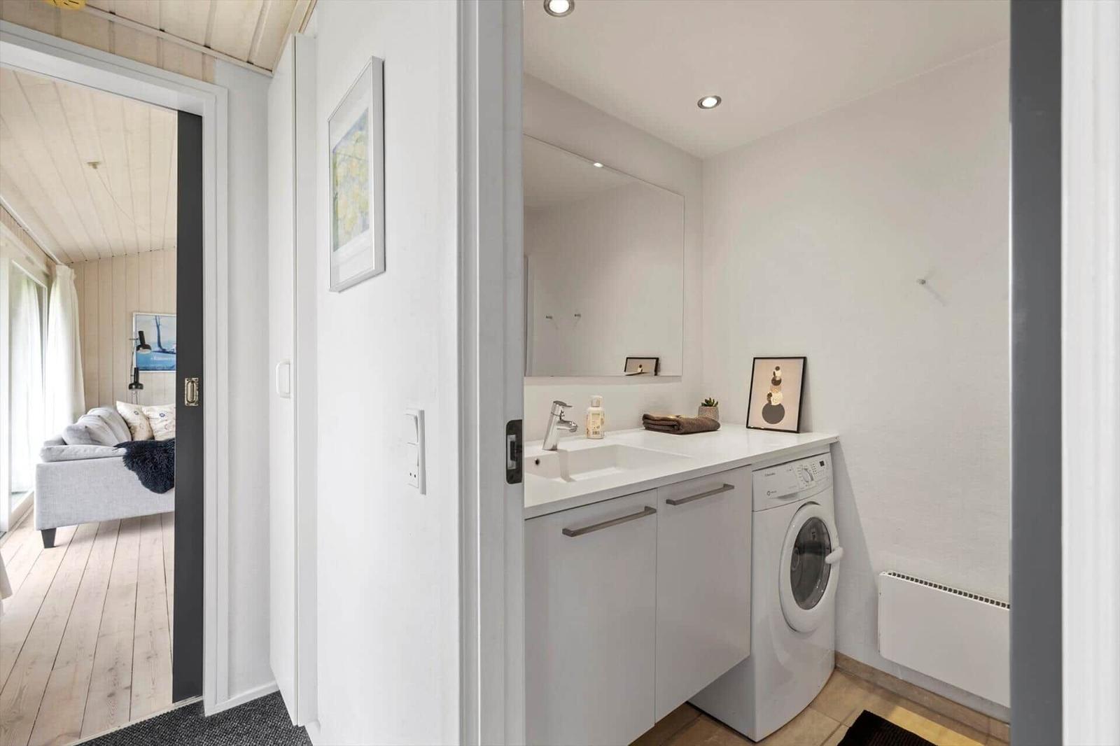 Waschbereich mit Waschmaschine und Spiegel. Durchgang zur Schlafzimmer.