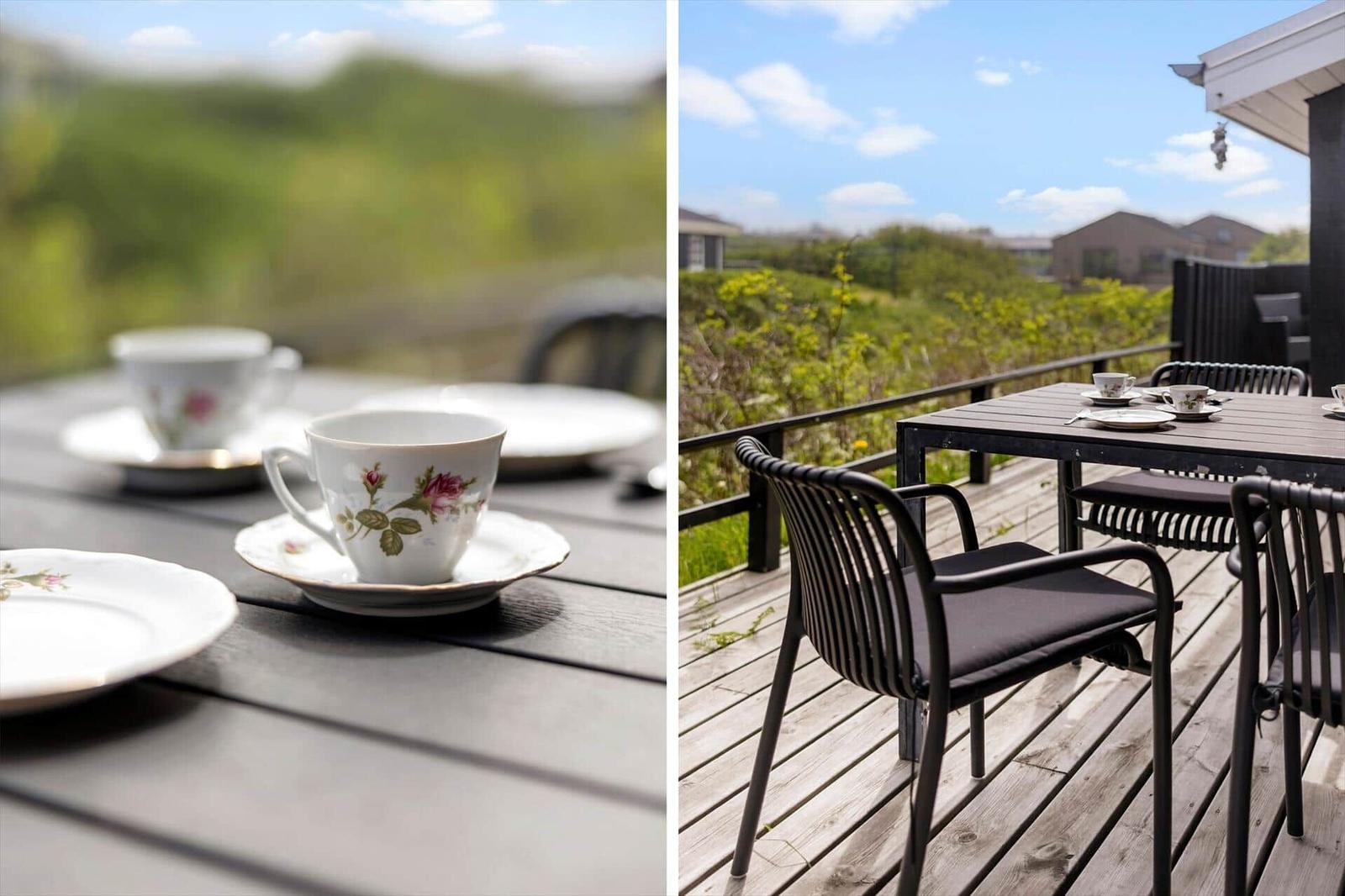 Tisch mit Tassen auf Terrasse mit Blick auf Grünflächen