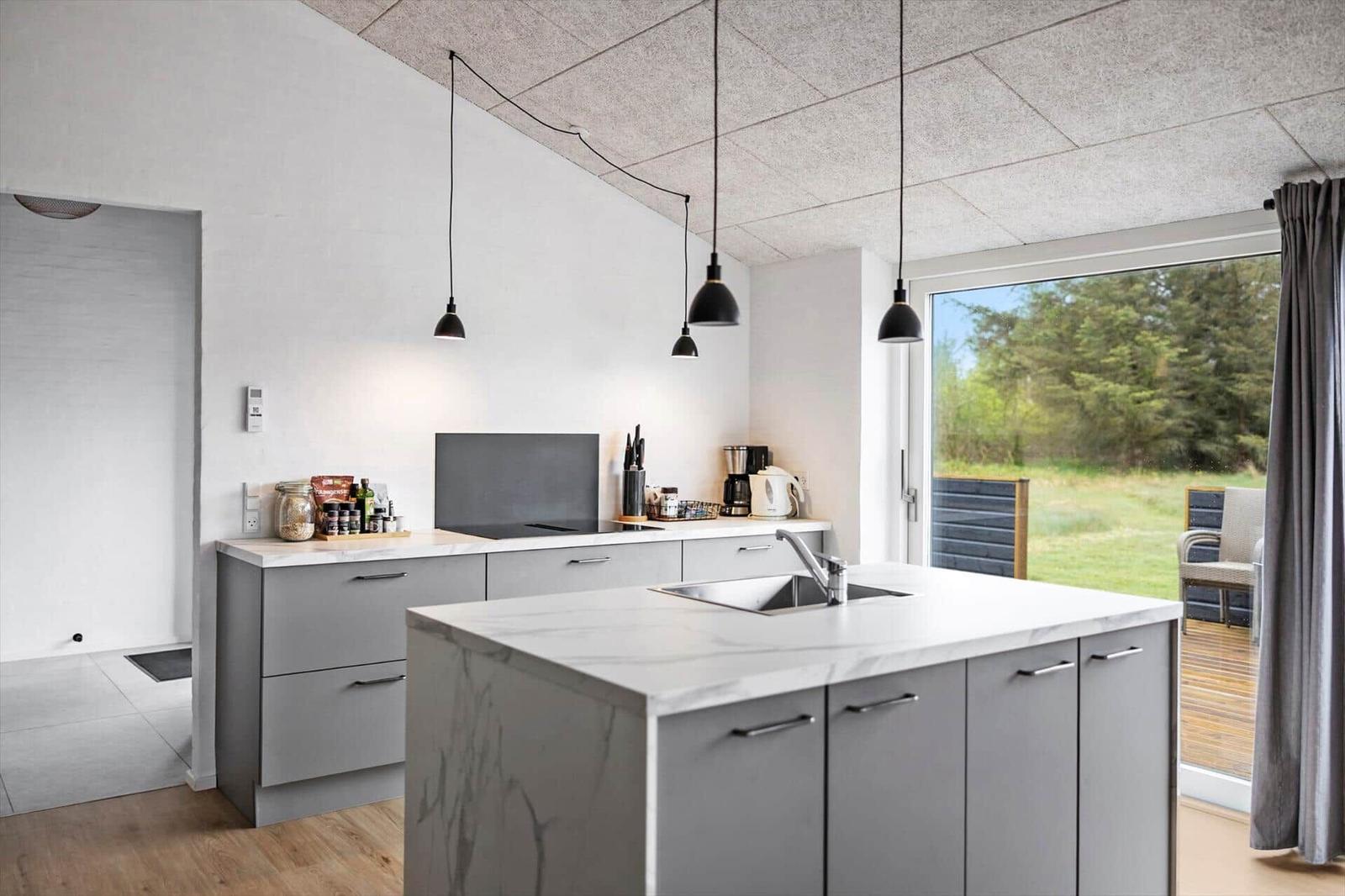 Moderne Küche mit Arbeitsplatz, Spüle und Fenster zum Garten