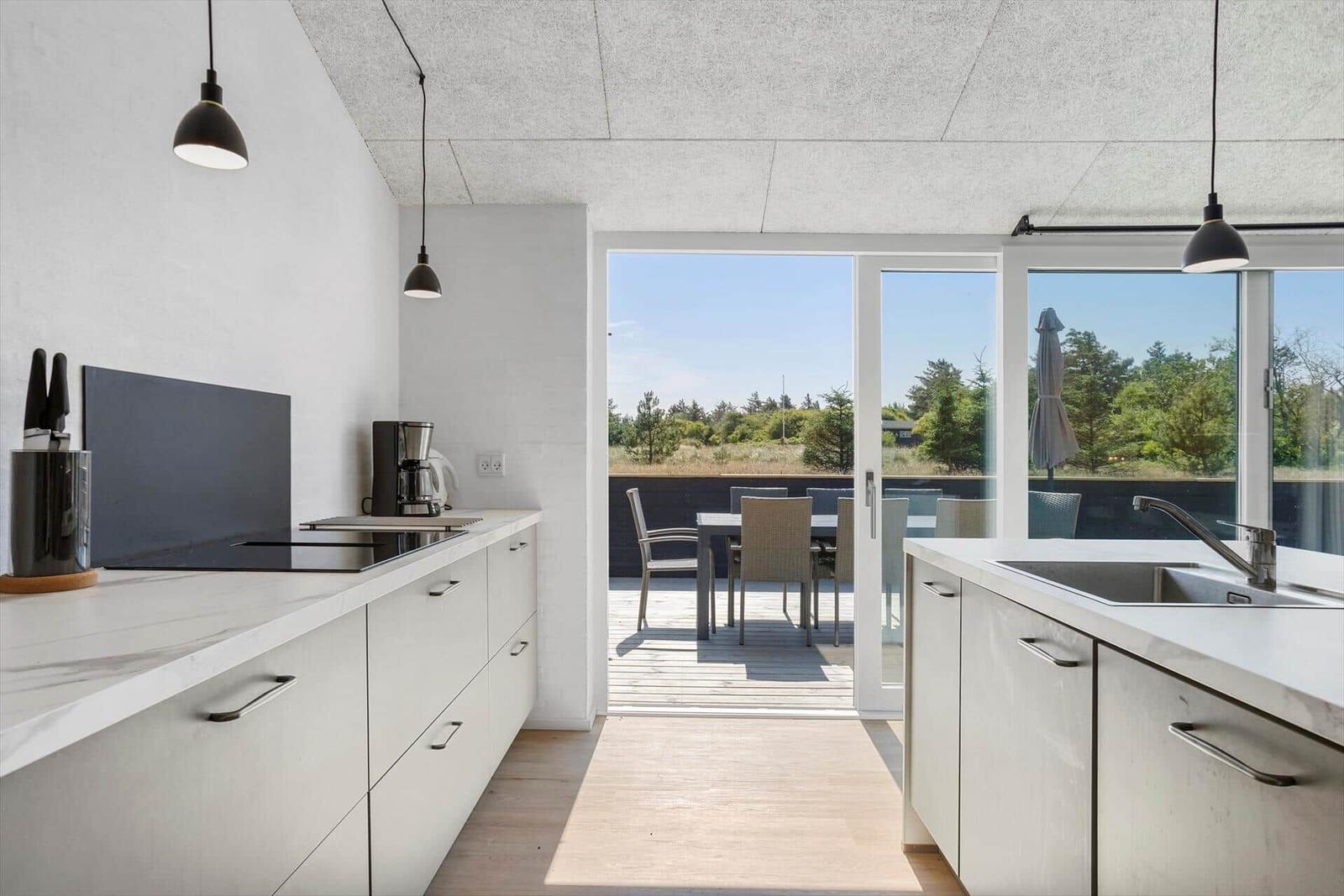Moderne Küche mit Blick auf Terrasse und Garten.