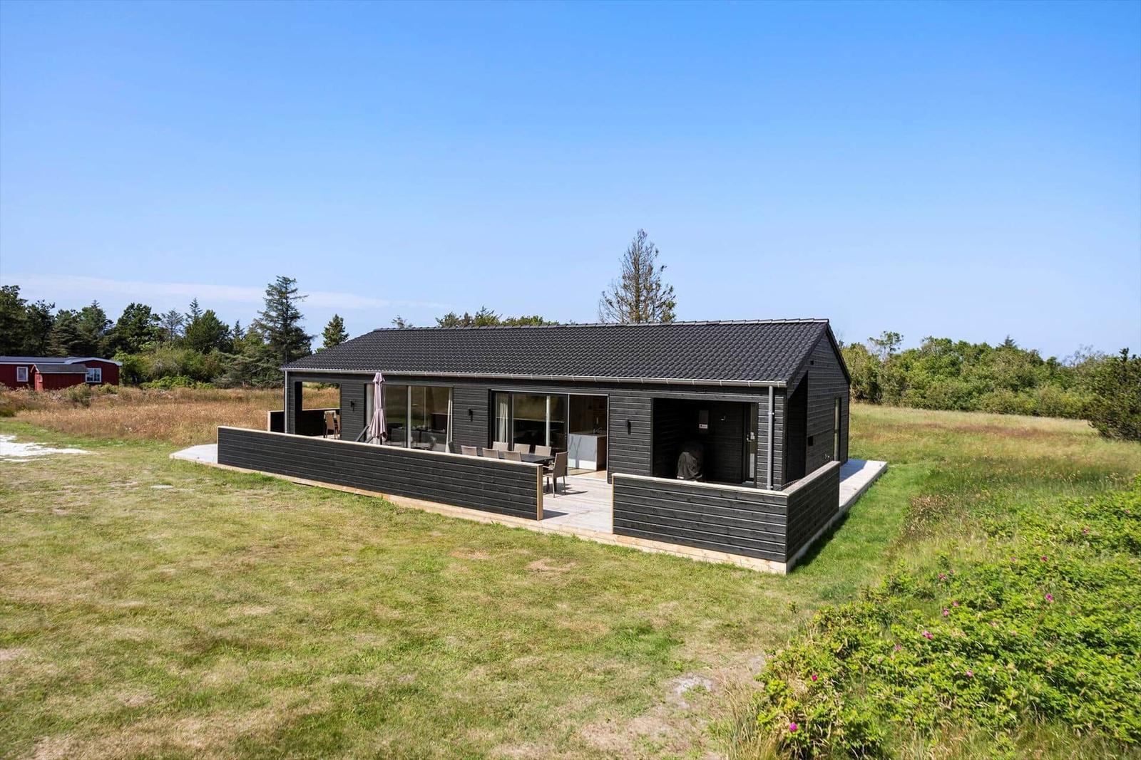 Moderne Holzhütte mit Terrasse und Garten. Blick auf die Umgebung.