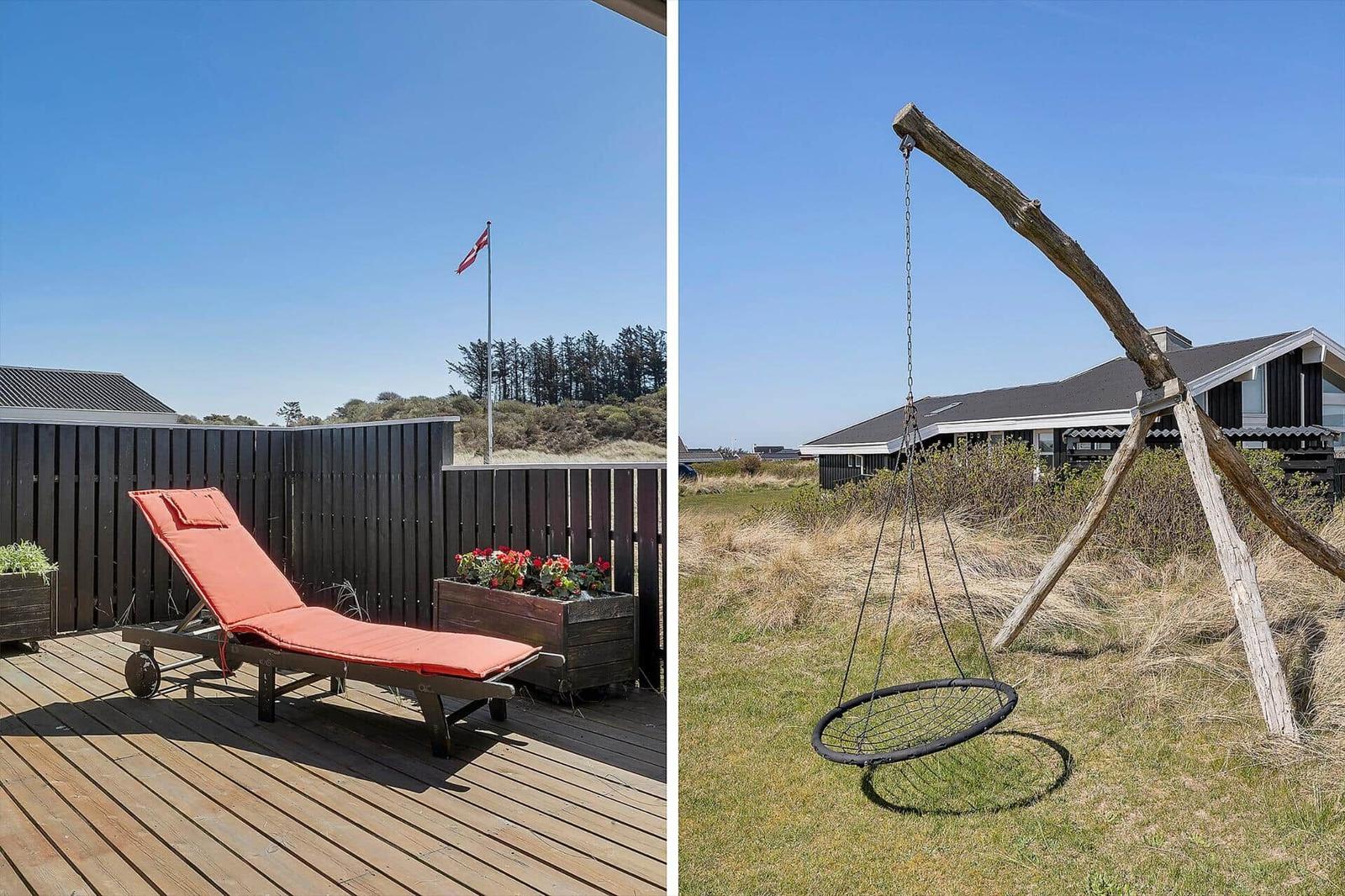 Terrasse mit Liegestuhl und Flagge. Hängesessel im Gras vor Haus.