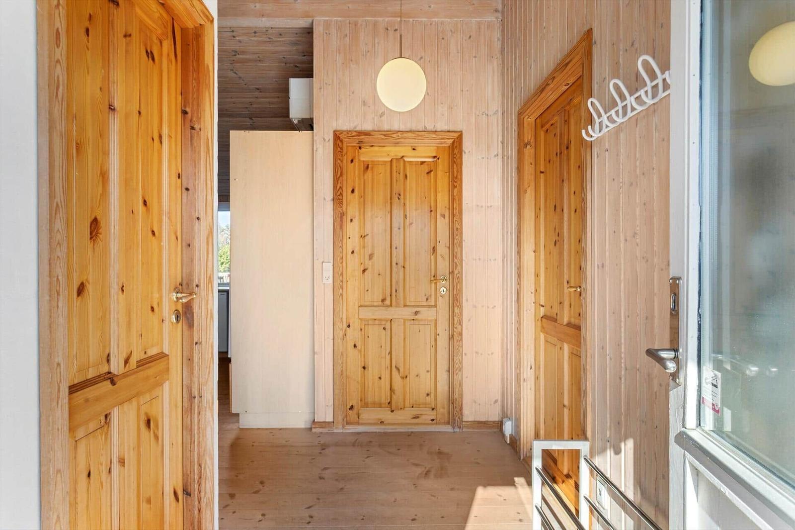 Holzgetäfelte Wohnung mit Türen und Fenster. Rundes Deckenlicht.