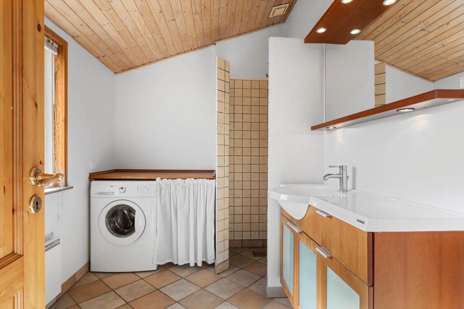 Wohnung mit Waschmaschine, Dusche und Waschbecken.