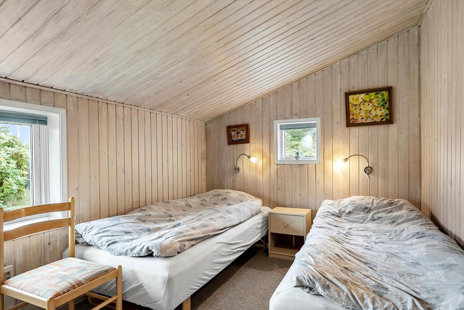 Zwei Betten, Holzwände, Fenster, Nachttisch, Wandlampen, Stuhl