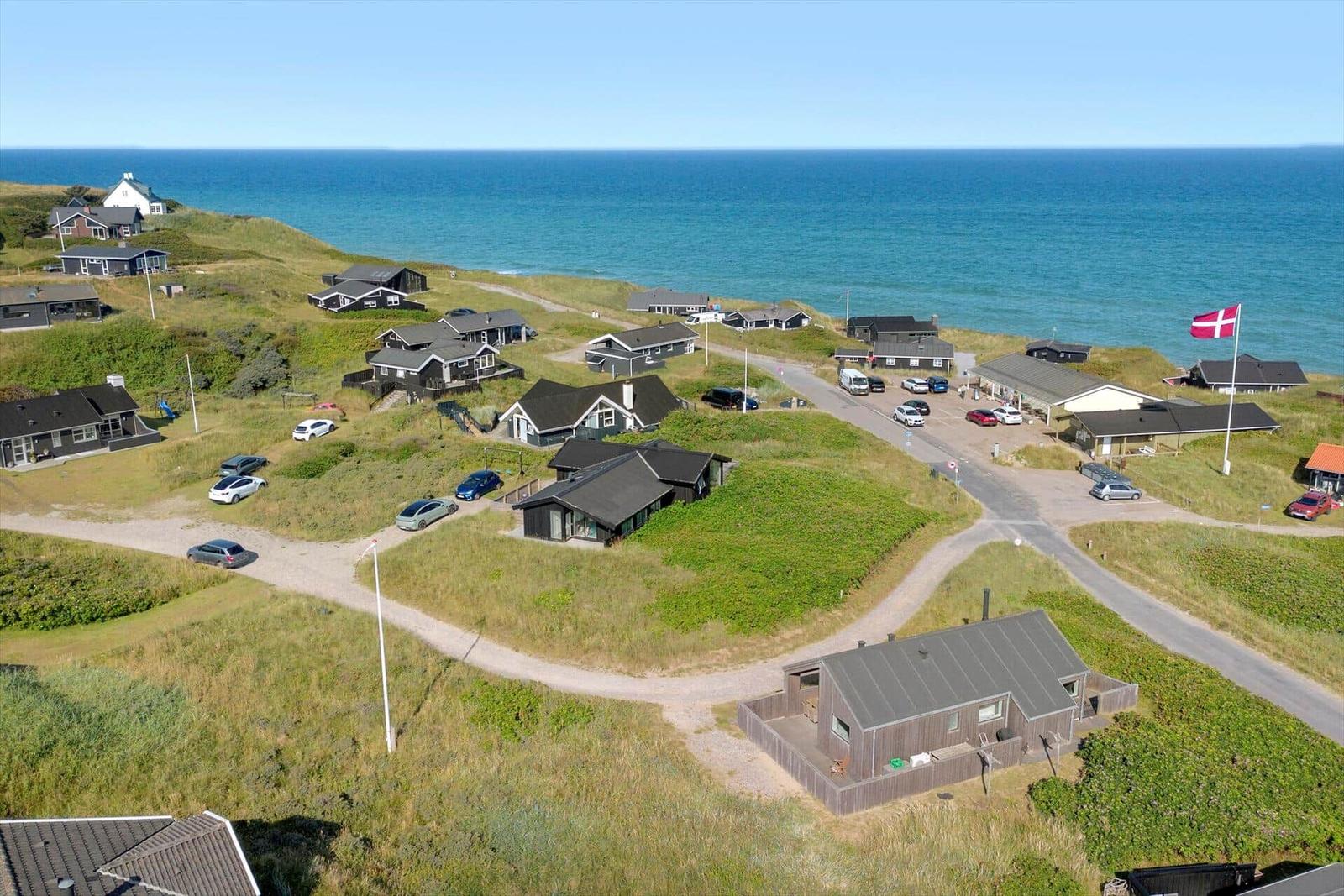 Seeblick auf Ferienhäuser mit Parkplätzen und dänischer Flagge