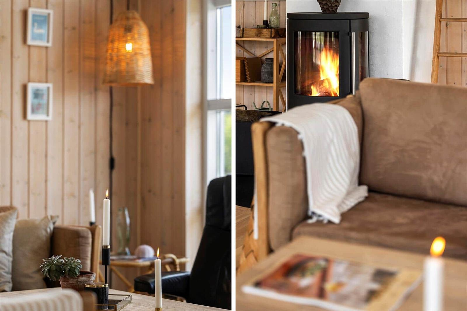 Wohnzimmer mit Kamin und Sofa. Holzwände, Kerzen und Tisch mit Zeitschrift.