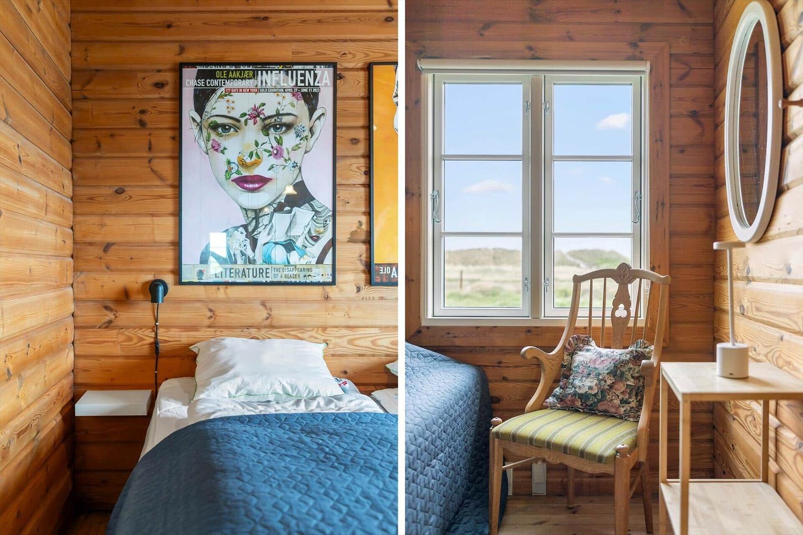 Schlafzimmer mit Holzwand, Bett und Wandbild. Fenster mit Stuhl und Spiegel.