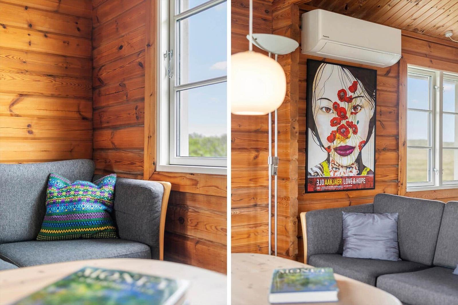 Holzvertäfelte Wand, grauer Sofa, Fenster, Wandbild und Stehlampe.