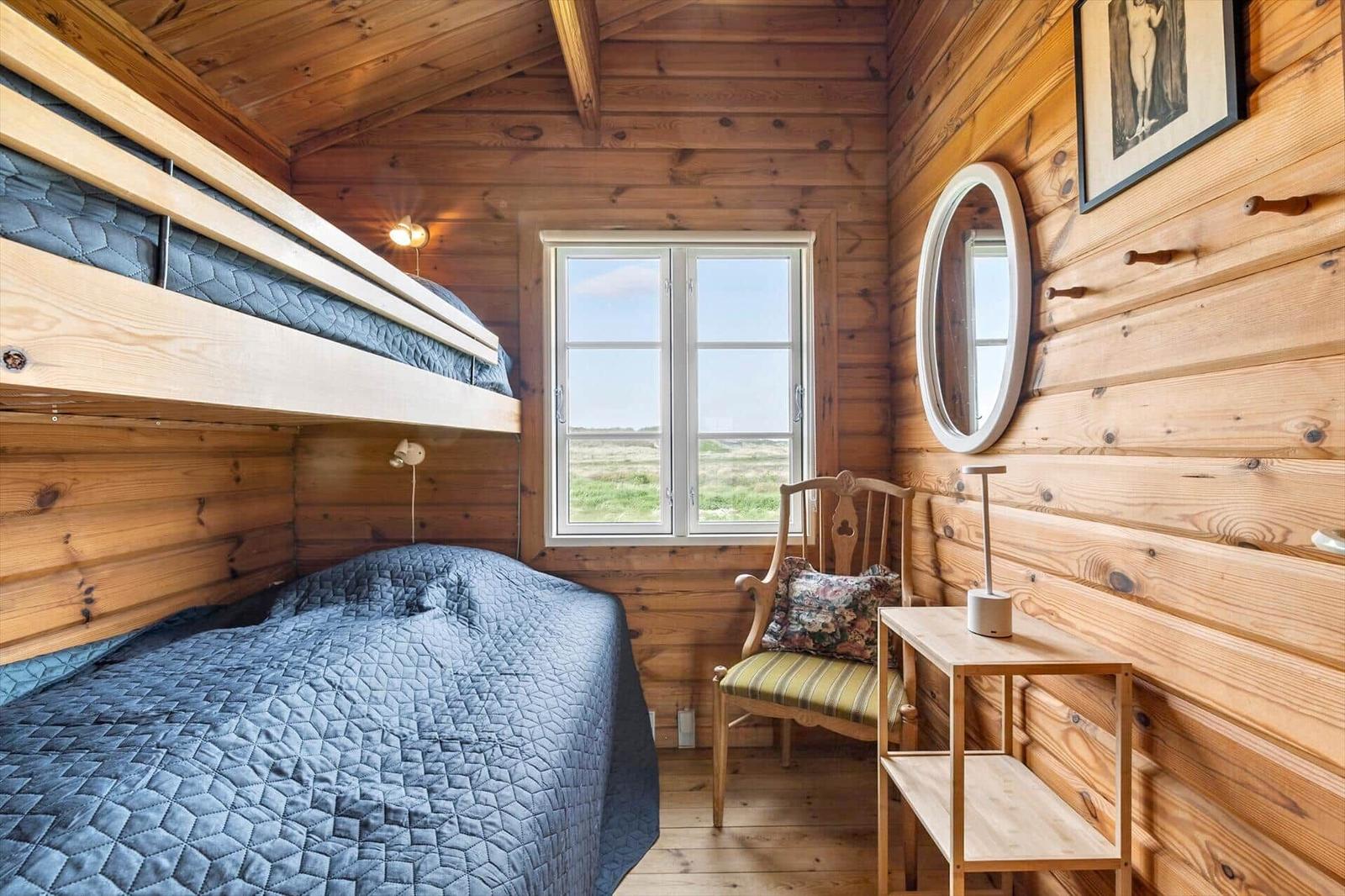 Zimmer mit Doppelbett, Schlafcouch, Fenster und Holzwand.
