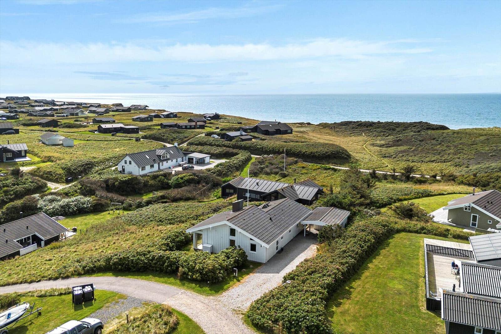 Häuser auf einer grünen Halbinsel mit Blick auf das Meer.