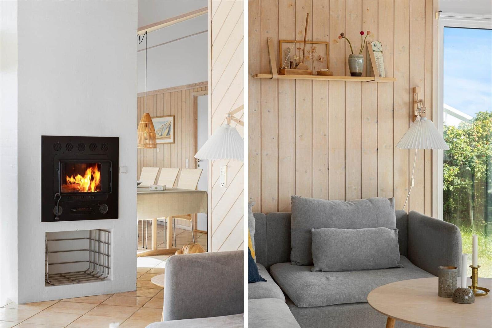 Wohnzimmer mit Kamin und Holzwand. Sofa, Tisch und Fenster sichtbar.