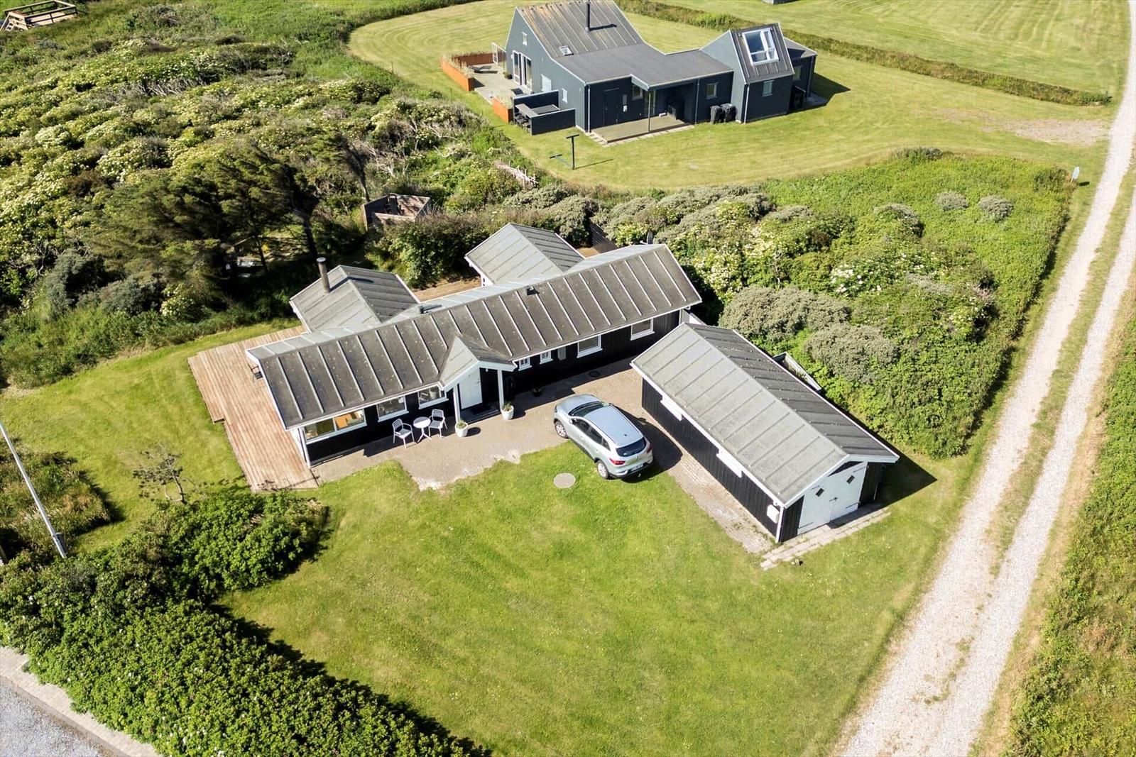 House with garage and garden. Car parked. Green areas and trees surround.
