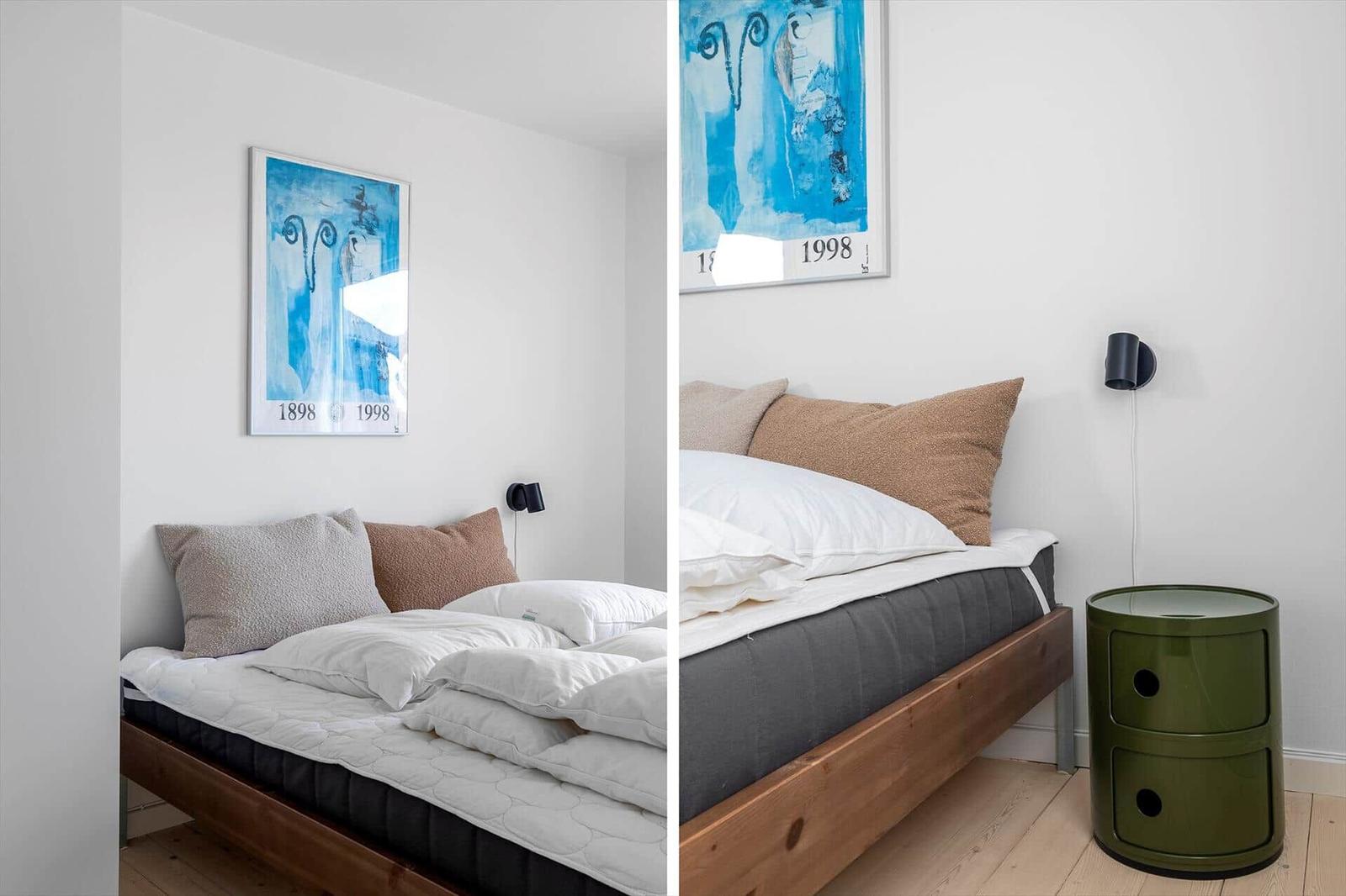 Schlafzimmer mit Bett, Kissen, Wandbild und Nachttisch.