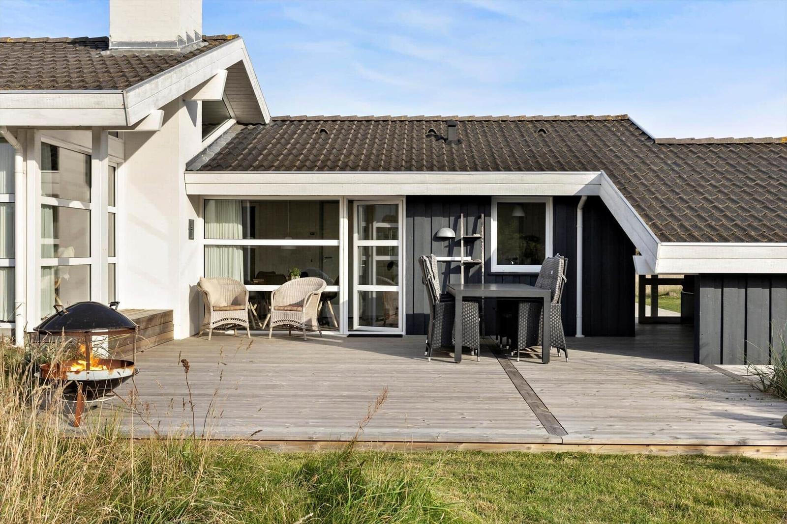 Terrasse mit Sitzgruppe, Grill und Blick in das Haus.