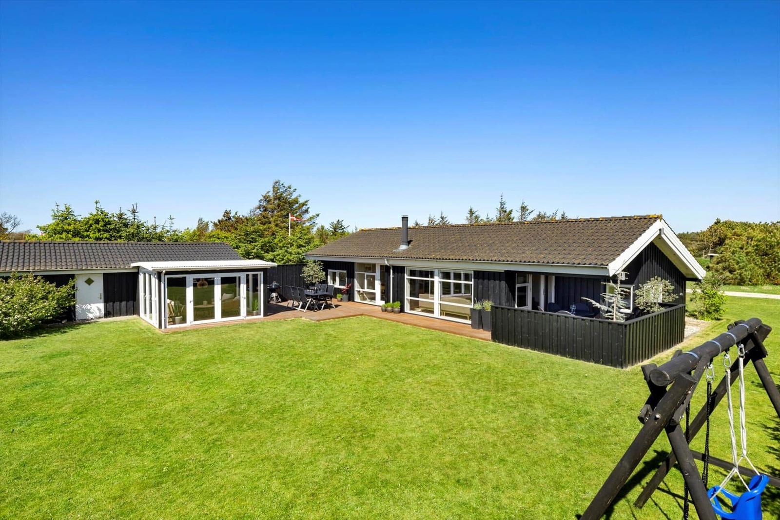 Modernes Ferienhaus mit großem Garten und Terrasse. Spielgeräte und Grillplatz vorhanden.