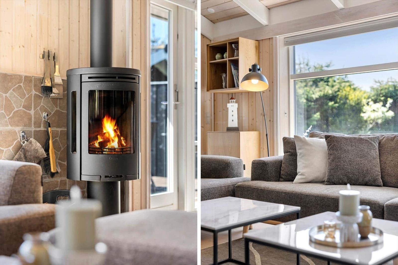 Ein Wohnzimmer mit Kamin und Sofa, große Fenster und Holzwand.