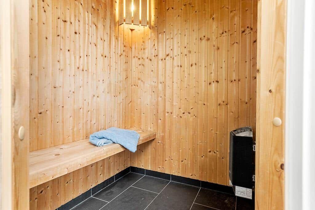 Sauna mit Holzwand, Sitzbank und blauem Handtuch.