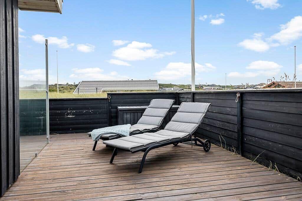 Terrasse mit zwei Liegestühlen und Blick auf die Landschaft.