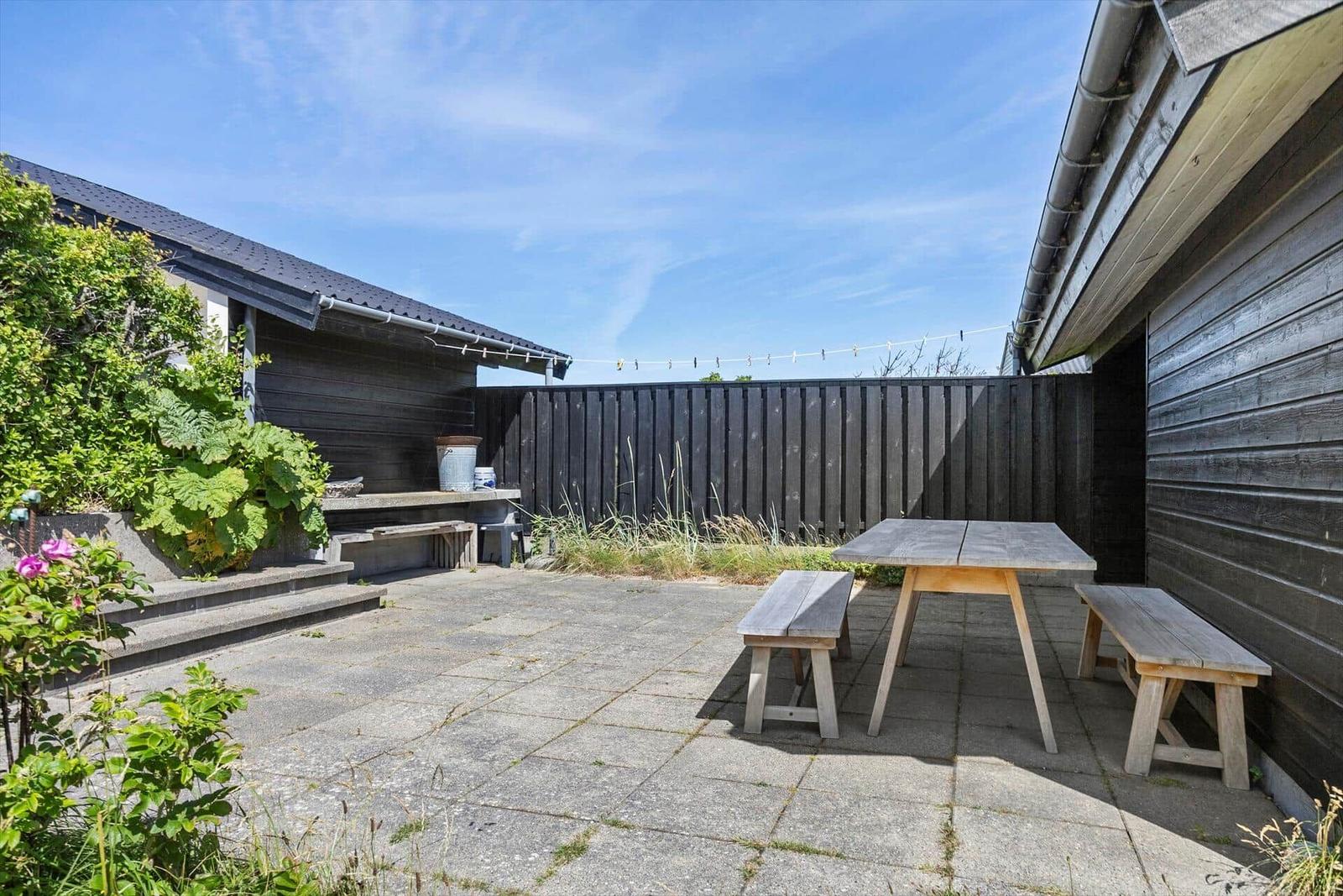 Hinterhof mit Tisch und Bänken, Pflanzen und Zaun