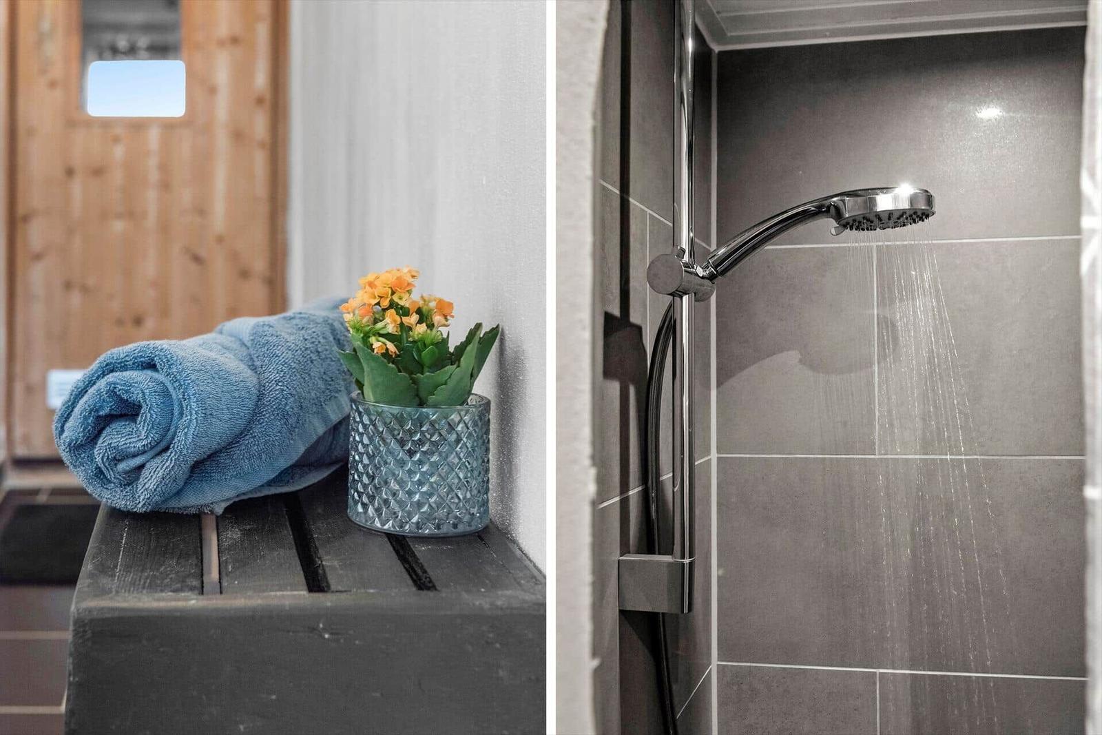 Badezimmer mit Dusche und blauer Handtuchrolle auf Holzbank.