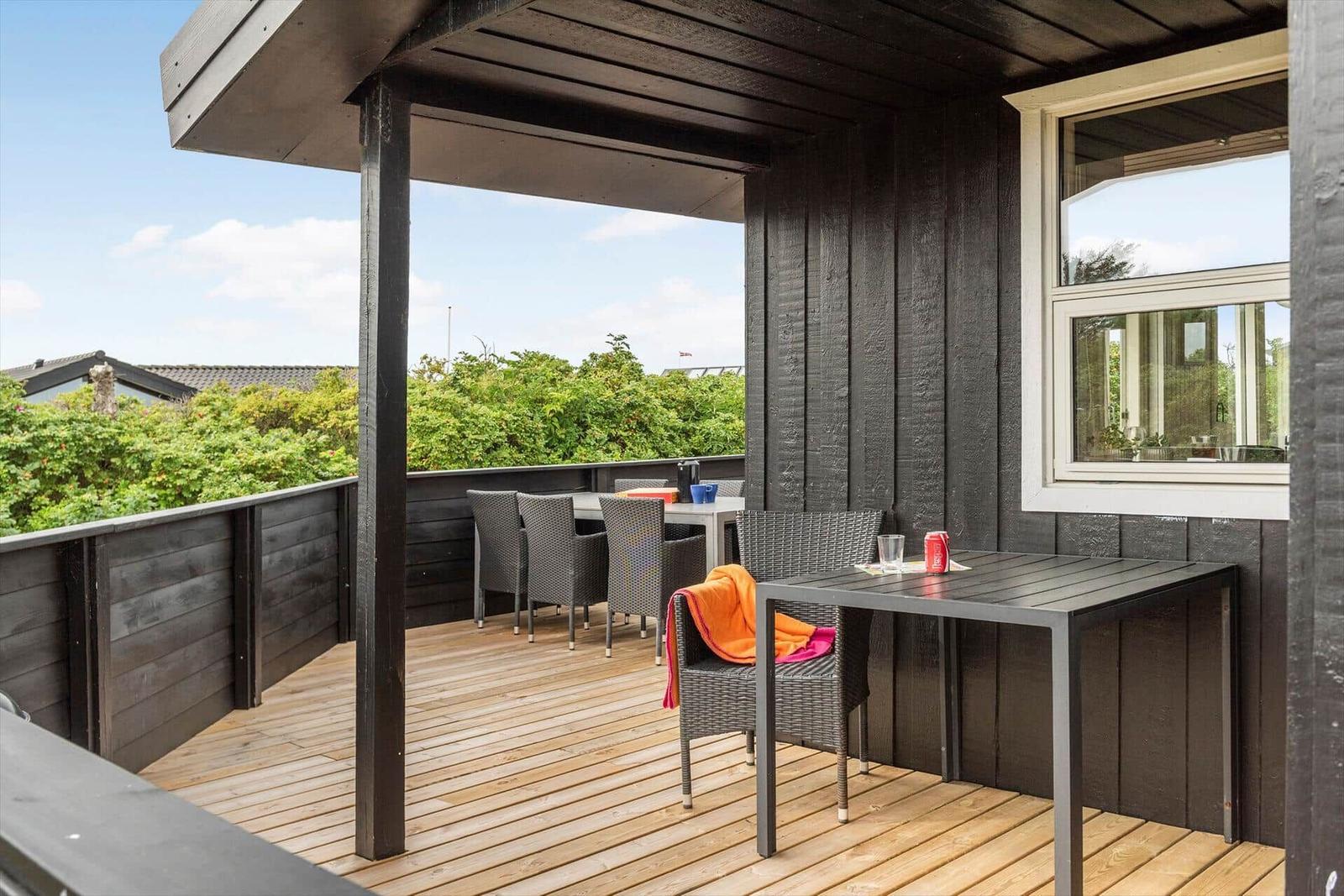 Terrasse mit Tisch, Stühlen und Blick auf Grünflächen