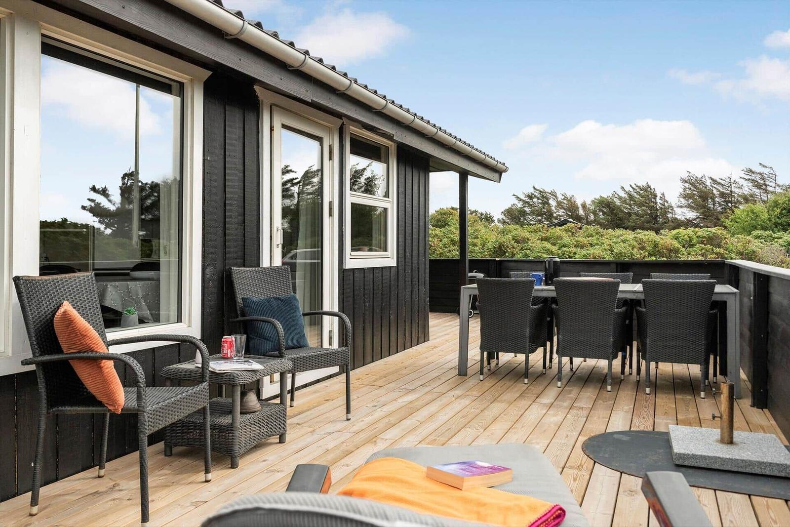 Terrasse mit Sitzgelegenheiten und Blick auf Grünflächen.